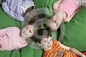 Boy and three girls (5-7) lying on back portrait view from above