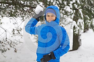 Boy throw snowball. Wintertime fun