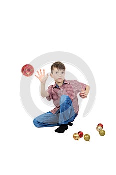 Boy throwing a Christmas tree ball on white background.