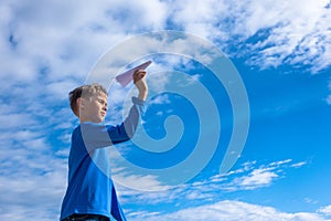 Boy throwing white paper plane.