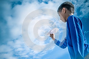 Boy throwing white paper plane.