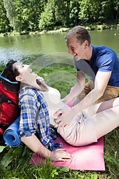 Boy tickling girl by the lake