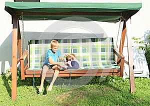 Boy tickling girl on a wooden swing