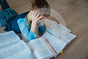 Boy tired of reading, kid stressed by doing homework