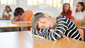 Boy is tired and sleeping at the desk in classroom