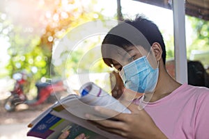 The boy is tired of studying at home in a protective mask during his detention