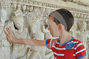 A boy touches historical monument