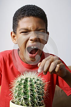 Boy touching cactus.