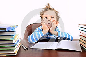 Boy with tousled hair sitting at a desk