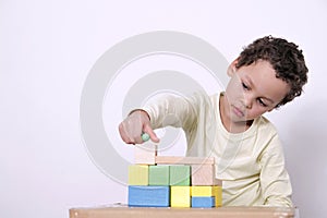 Boy with toy building blocks building towers learning and been educated at school stock photo