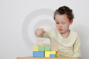 Boy with toy building blocks building towers learning and been educated at school stock photo