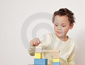 Boy with toy building blocks building towers learning and been educated at school stock photo