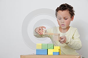 Boy with toy building blocks building towers learning and been educated at school stock photo