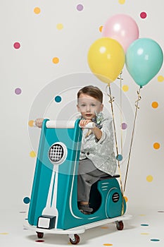 Boy on a toy motorcycle on a white background