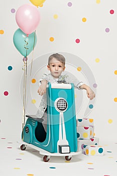 Boy on a toy motorcycle on a white background