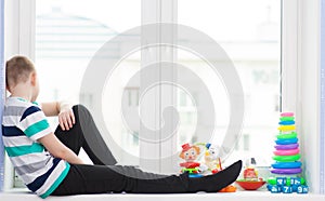 Boy with toys on a windowsill