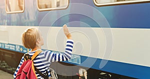 Boy on the train station wave goodbye. Kid with backpack on a subway