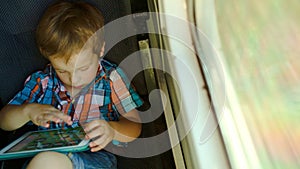 Boy in train using tablet computer