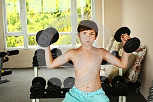 boy training with dumbbells in gym