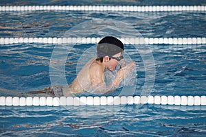 The boy trains in swimming pool, before the compet