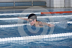The boy trains in swimming pool, before the compet