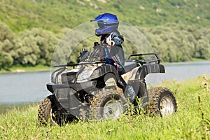 The boy is traveling on an ATV