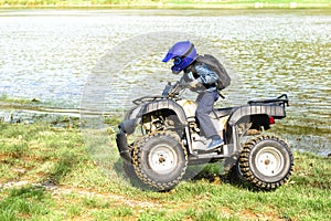 The boy is traveling on an ATV