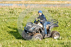 The boy is traveling on an ATV