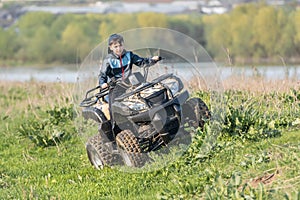 The boy is traveling on an ATV