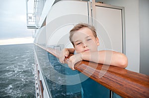 Boy traveling on ship and hold on handrails photo