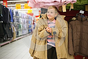 Boy tries on jacket in shop