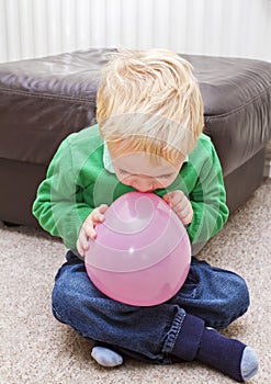 Boy trying to blow balloon