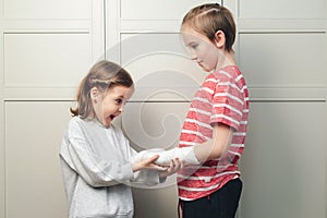 Boy two broken arms, girl is in shock. Shocked surprised boy with arm in sling. Boy has a cast on his arm. Child girl holding his