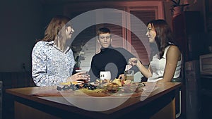 The boy and two girls are drinking tea.