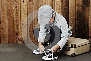 Boy tying shoelace on case