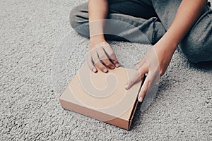 A boy unboxing unpacking a parcell, delivery, online shopping purchase concept