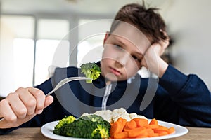 Boy unsatisfied with vegetable lunch