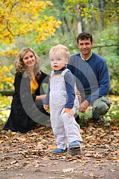 Boy with untied lace and parents in park