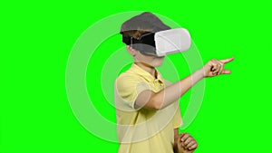 Boy use virtual reality headset helmet. Green screen