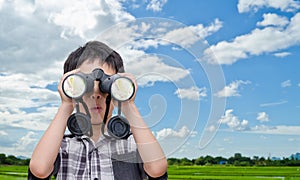 Boy using binoculars in field