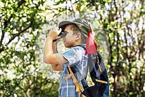 Boy using binoculars in the forest