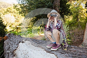 Boy using binoculars in the forest