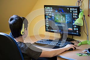 Boy using computer at home, playing game