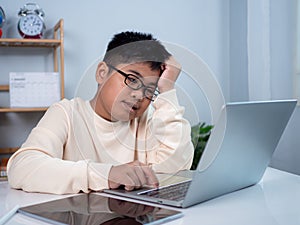 Boy using computer for learning and stressed about online learning, Virtual internet online class from school teacher by remote