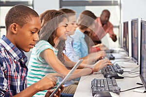 Boy Using Digital Tablet In Computer Class