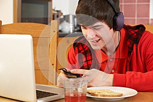 Boy Using Electronics Whilst Eating Breakfast