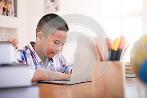 Boy using his laptop to learning online.