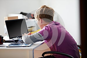 Boy Using Laptop In Bedroom