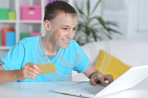 Boy using laptop at home shopping online