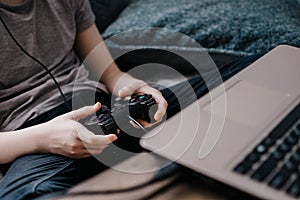 The boy using a laptop for playing online games.